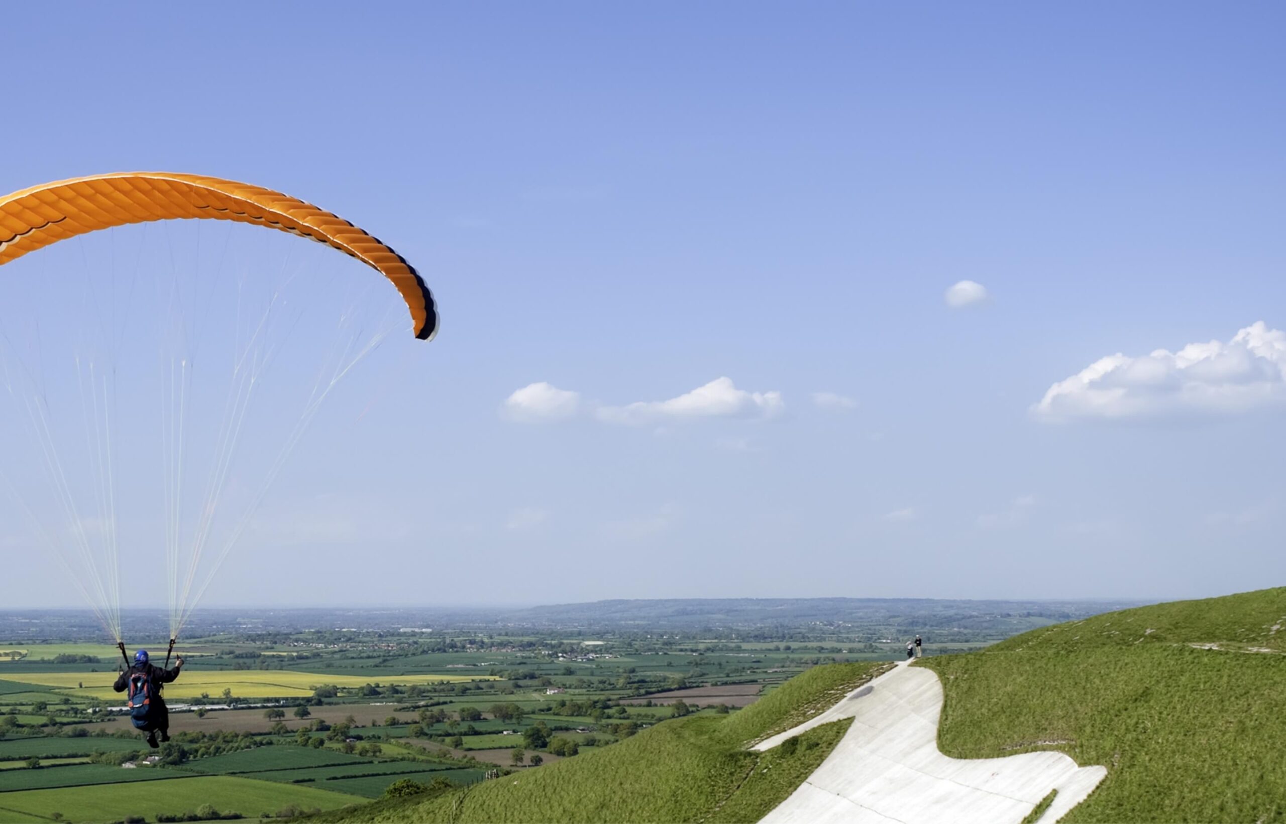 Person paragliding in Wiltshire countryside